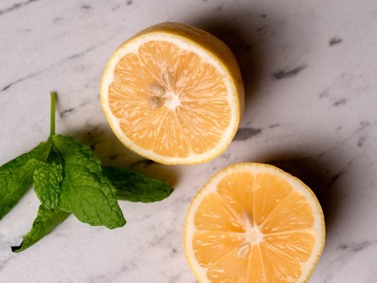 Half a lemon and fresh mint on a marble worktop