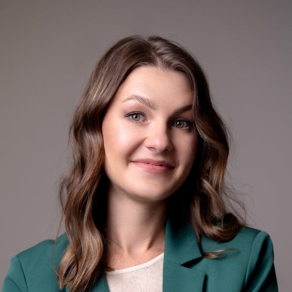 Natalia, smiling, in a green jacket