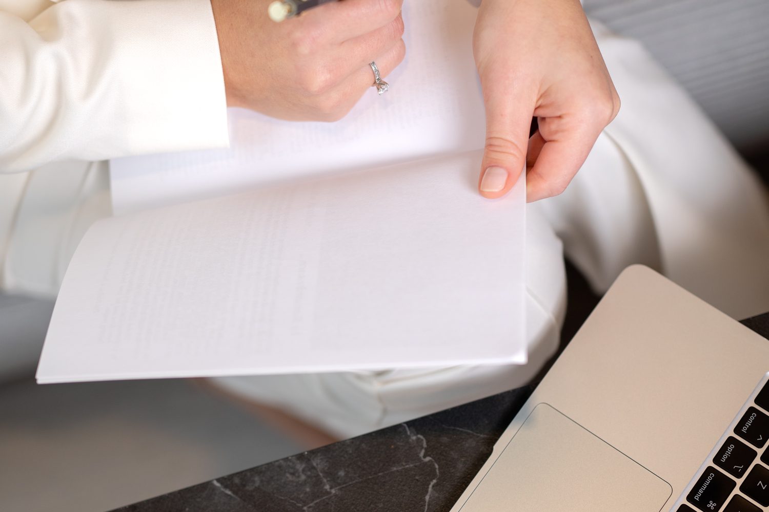 Writing notes in a notebook beside a laptop